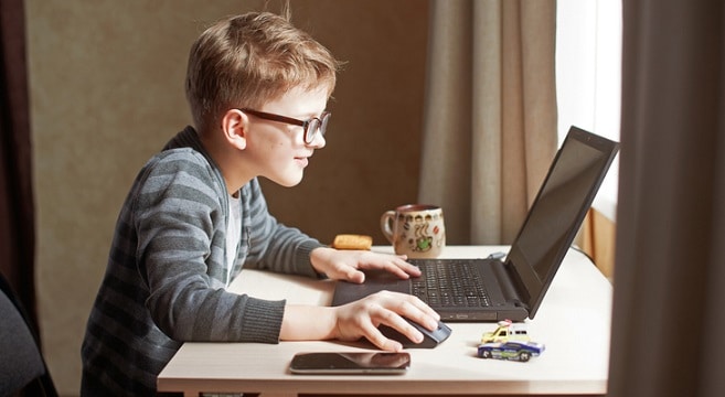 a little boy in front of laptop
